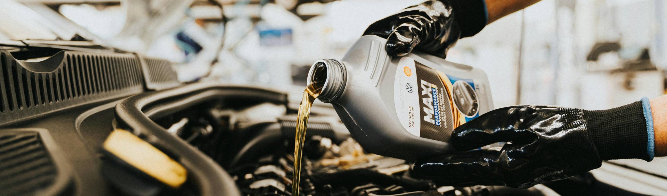 Technik dolévající motorový olej do auta